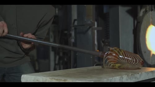 Glass Maker Shaping Molten Glassware With Tool