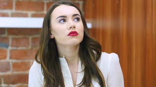Young Adult Woman Looks Up in Thought