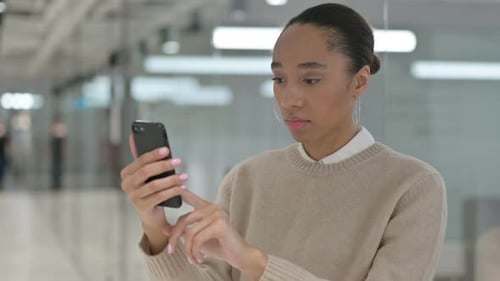 Woman Using Smartphone in Modern Office