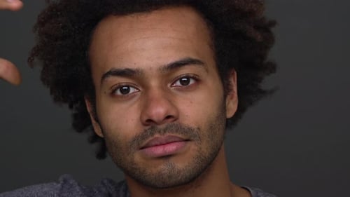 Man Smiles and Scratches his Head