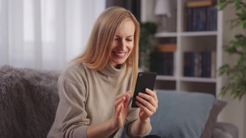 Woman Using Mobile Phone While Relaxing on Couch