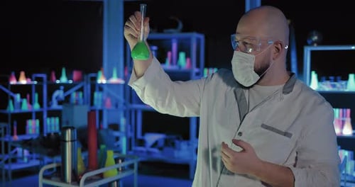 Scientist Inspecting Colorful Solutions in Futuristic Lab