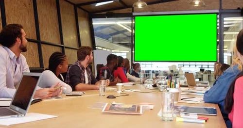 Adults at Conference Table in Modern Boardroom
