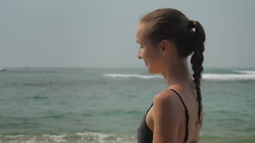 Dama en traje de baño llega a la playa disfrutando de un increíble paisaje oceánico