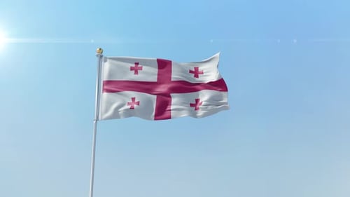 Waving Flag of Georgia Against Clear Blue Sky