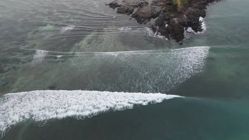 Aerial View of Waves Crashing on Rocky Coastline