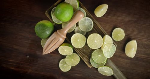 Round Slices of Lime on a Cutting Board with the Juicer Slowly Rotate