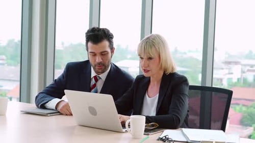 Two Business People Talk Project Strategy at Office