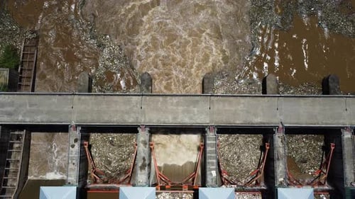 Aerial view of the water released from the concrete dam's drainage channel as the overflow