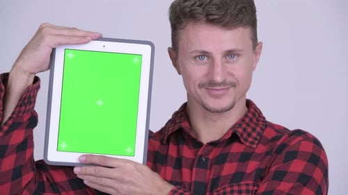 Young Man Holding up Tablet with Green Screen