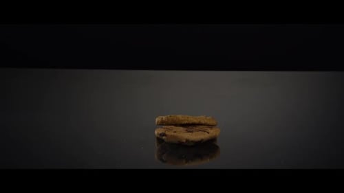 Falling cookies from above onto a reflective surface