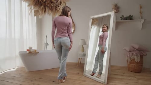 Woman admiring her outfit in mirror in bathroom