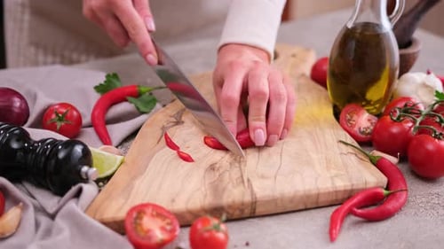 Woman Prepares Spicy Food with Chili Pepper
