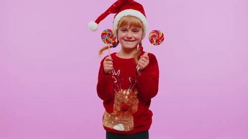 Funny Girl in New Year Sweater Holding Candy Striped Lollipops Hiding Behind Them Fooling Around