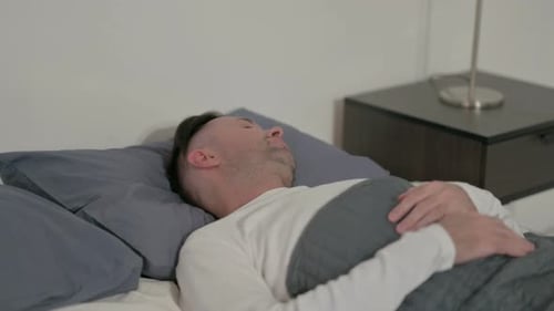 Man Sleeping Peacefully in Bed in Bedroom