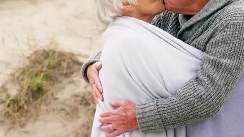 Senior Couple Share Romantic Kiss on Beach