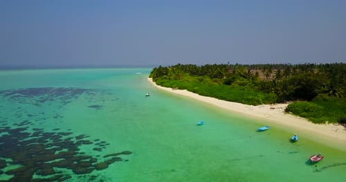 Wide angle fly over island view of a paradise sunny white sand beach and aqua blue water background