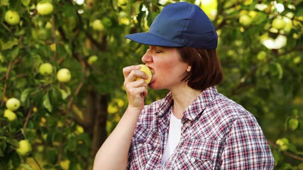 Mujer joven mordiendo y masticando manzana en el huerto , Grabaciones ...