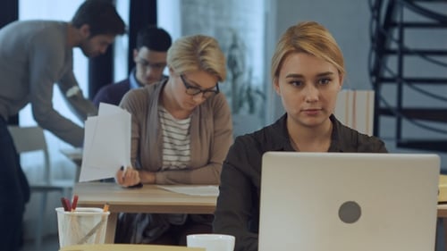 Young woman working on laptop in the modern office