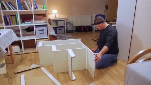Un travailleur avec caméra assemble des meubles