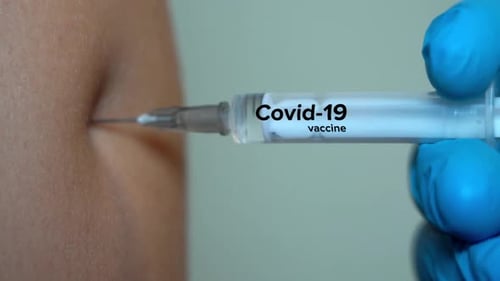 Needle Pierces Skin with Covid-19 Vaccine