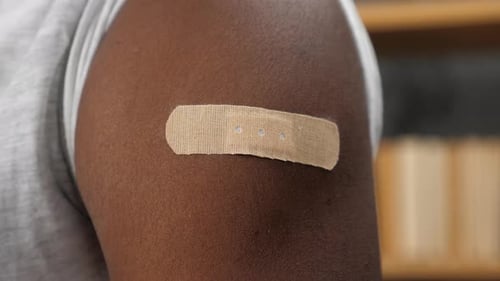Close Up Vaccinated African American Man with Medical Plaster on Shoulder