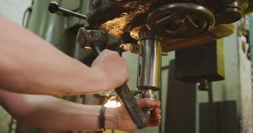 Kaukasischer Mann händet Fabrikarbeiter in einer Fabrik, steht an einer Werkbank und bedient Maschinen