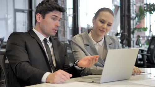 Business Colleagues Discussing Ideas at Office Desk
