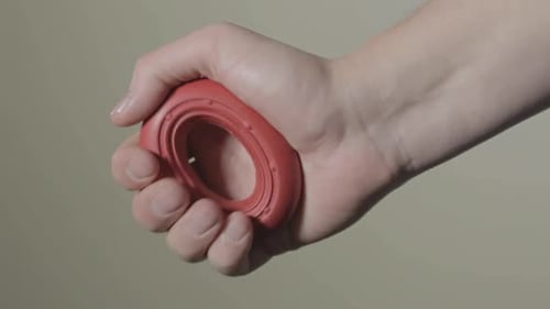 Hand Squeezing a Red Grip Strengthener
