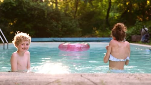 Two Kids Boy and Girl Having Fun in the Pool