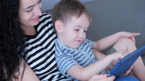 Woman and Child Enjoying Tablet Technology at Home