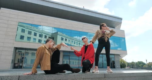 Stylish Friends Posing in Front of Modern Building