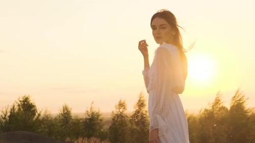 Beautiful Woman in White Dress Posing at Sunset