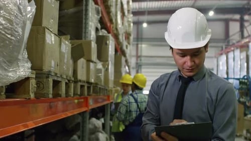 Warehouse Supervisor Checking Boxes