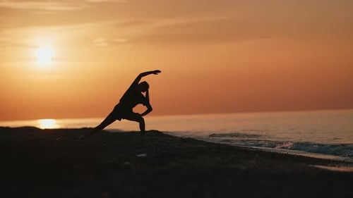 Silhouette of Fitness Woman Practicing Asana Yoga Pose on Beach