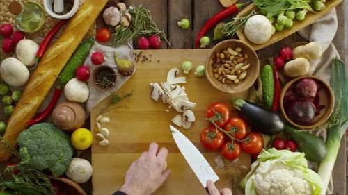 Person Slicing Mushrooms With Colorful Vegetables Surrounding