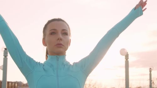 Woman Exercises on Urban Rooftop at Sunrise