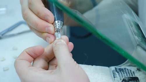 Dental Technician Shapes a Tooth with Precision Instrument