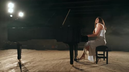 Elegant Woman Plays Grand Piano on Stage