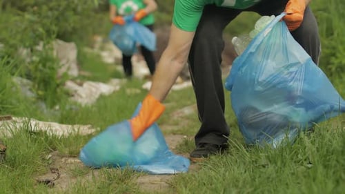 Equipo de voluntarios limpiando un parque sucio con bolsas de plástico y botellas. Reduzca la contaminación por celofán de la basura