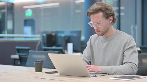 Young Businessman Working on Laptop in Office