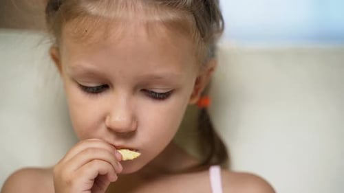 Little Girl Eating Chips in a Close Up Shot