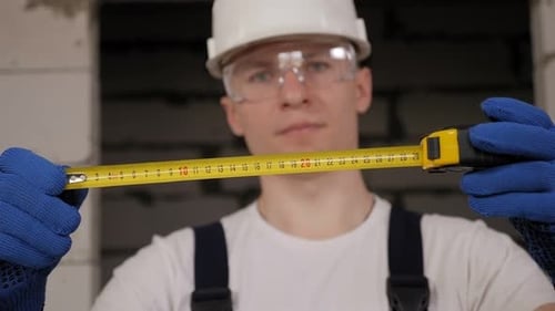 Portrait of a Male Construction Worker in a Helmet Holding a Roulette Wheel