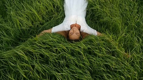 Junge süße Frau träumt von der Natur. Schöne junge Frau liegt auf dem Feld.