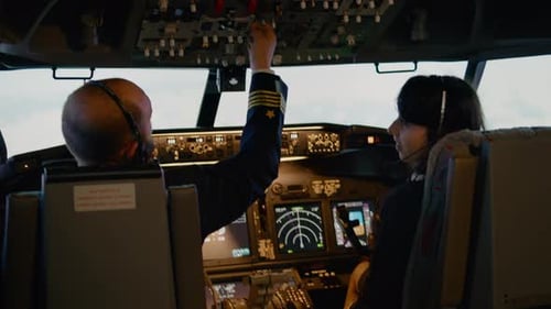 Capitão de avião e copiloto fêmea trocando nível de altitude e longitude