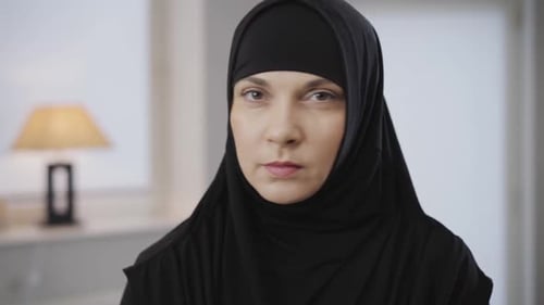 Porträt einer schönen muslimischen Frau, die in die Kamera schaut und durch Kopfschütteln Nein gestikuliert. Portrait von