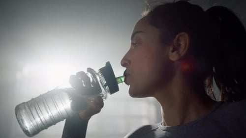 Fit Woman Hydrating After Workout in Gym