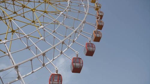 Big Ferris Wheel Rotates at Amusement Park Ride Over Clean Blue Sky