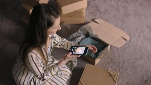 Woman Photographs Unboxing Experience with Smartphone