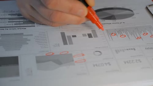 Businessman Analyzing Stock Market Report Candlestick Chart With a Marker